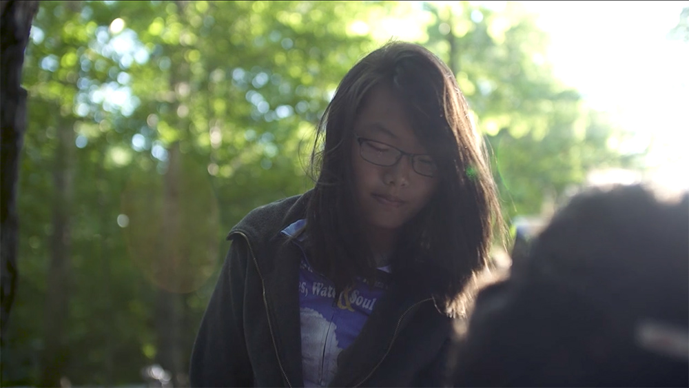 Cindy, a young Spoke'n Revolution rider looks down thoughtfully