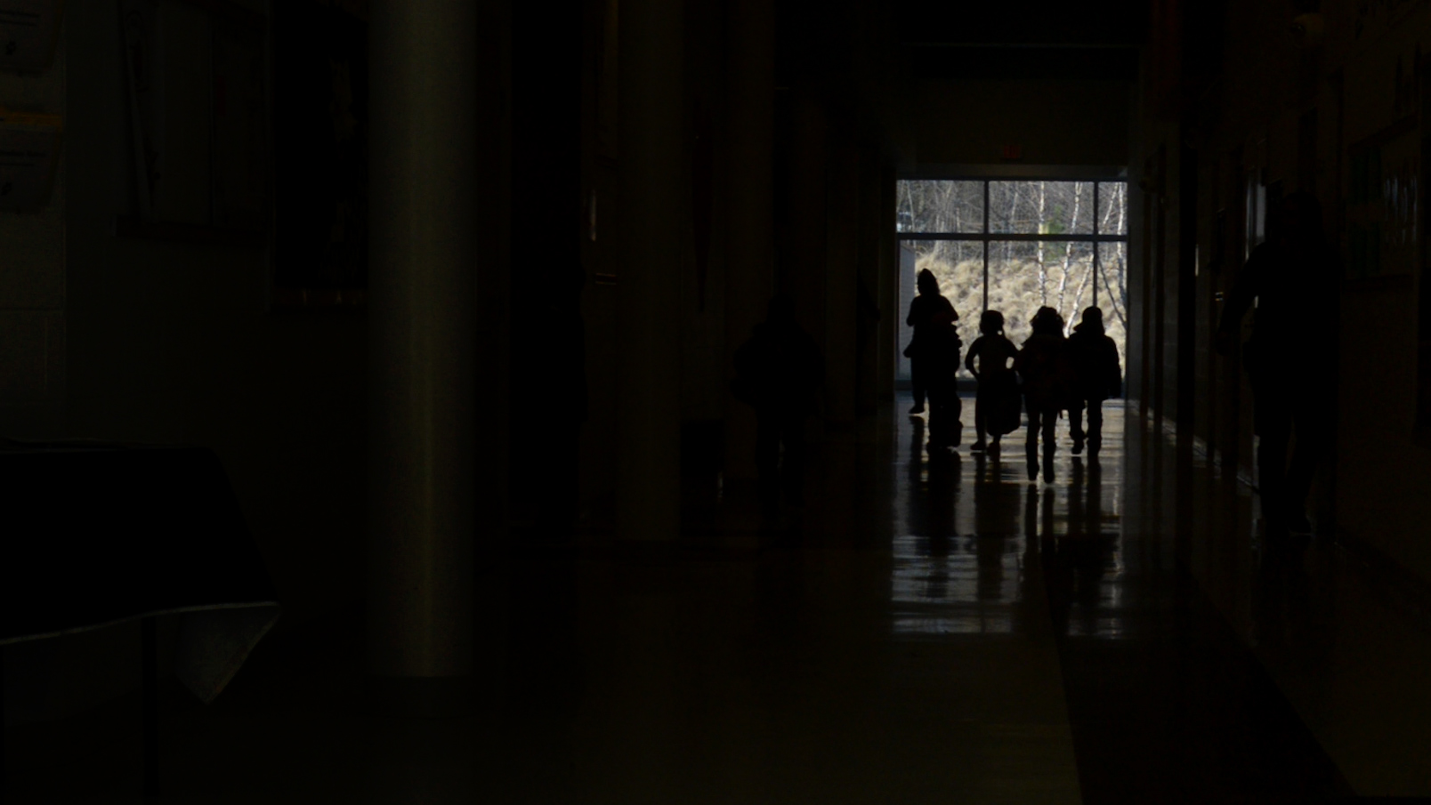 Silhouette of children walking down a school hallway